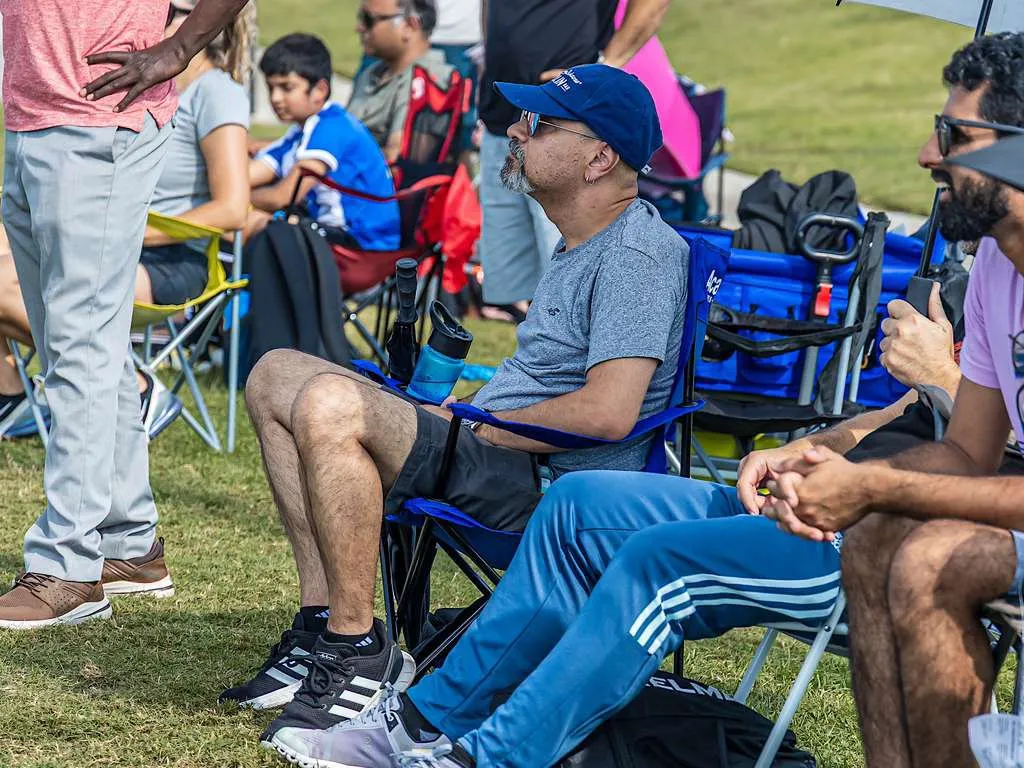 Parent watching the match from a sideline chair
