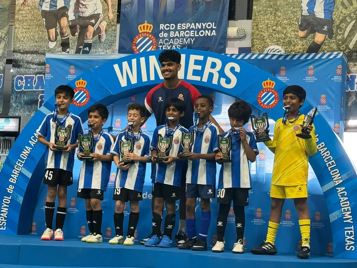 RCDE Academy Texas champions on the WINNERS podium with trophies and medals