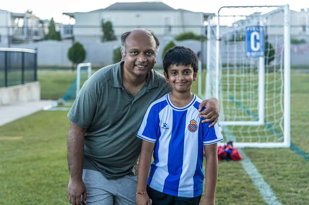 Father and son posing in front of the goal